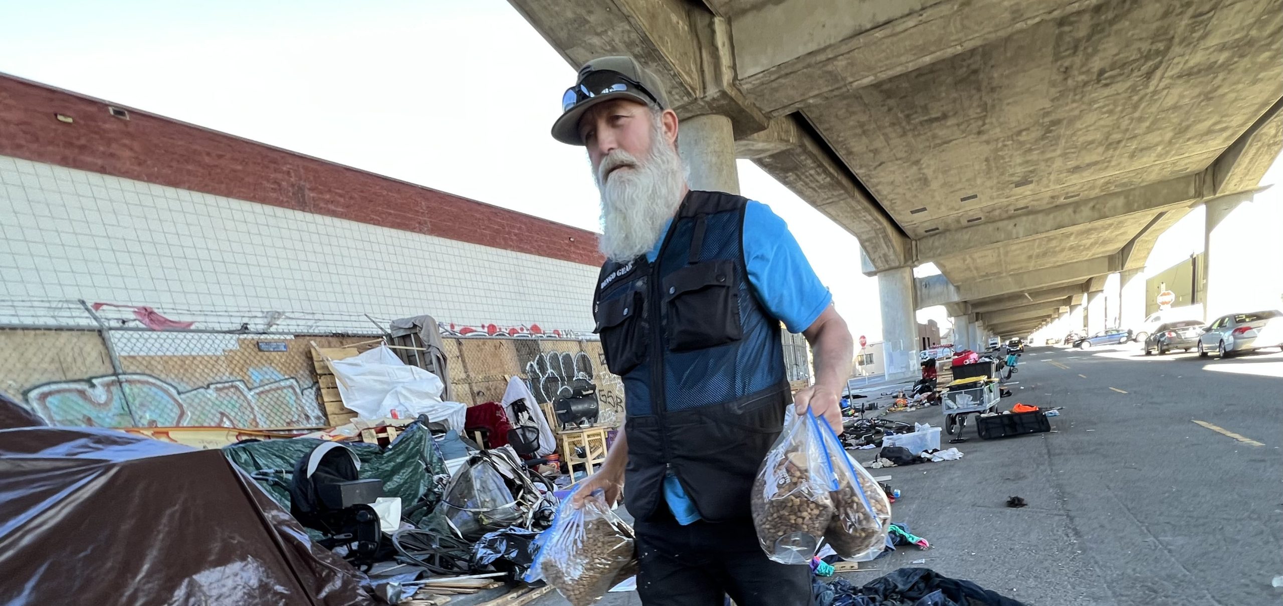 Like a Santa Claus for dogs of the homeless, he travels miles, his cart loaded with food, blankets, medications and toys