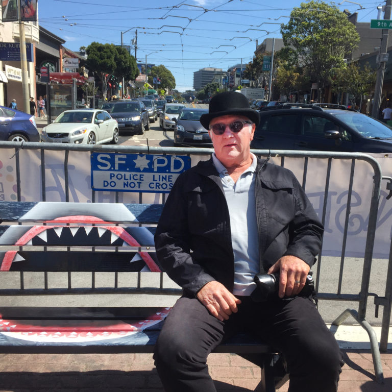 Photo of Christ Duderstadt sitting on his bench painted with "Jaws"